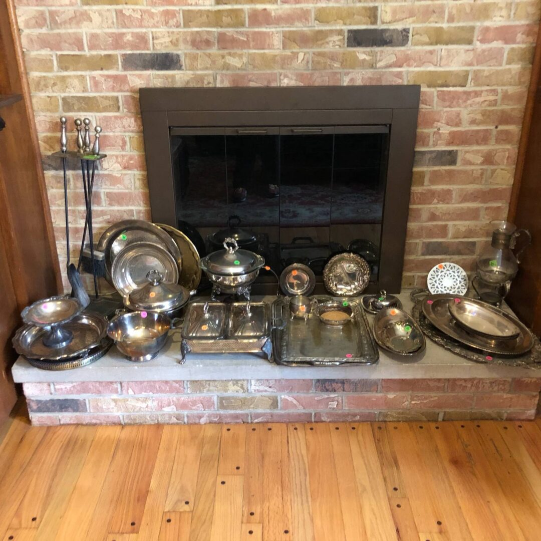 A collection of silverware in front of a fireplace