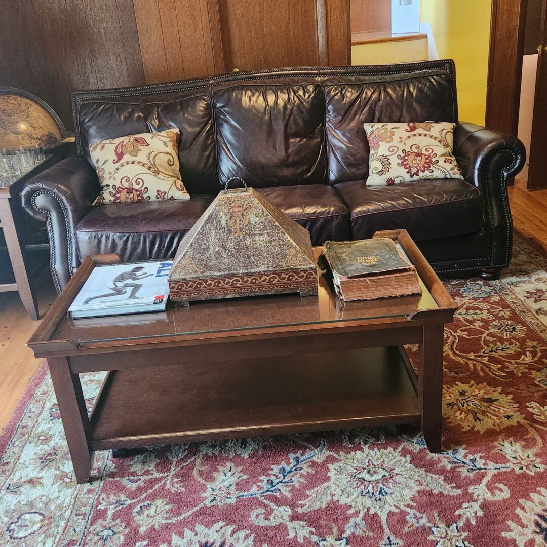 A Three Seater Brown Color Couch on a Carpet