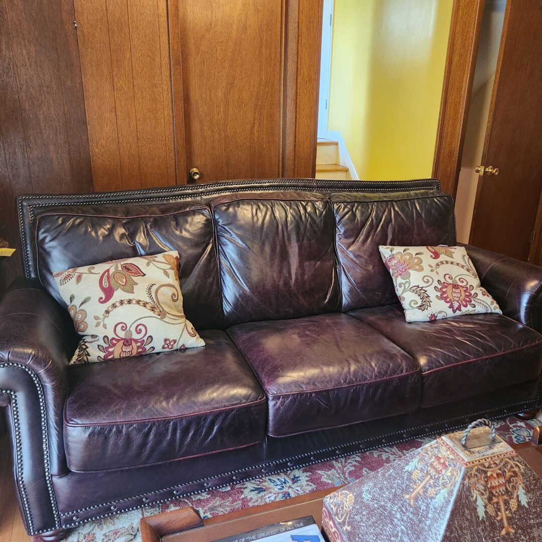 A Three Seater Dark Brown Color Couch