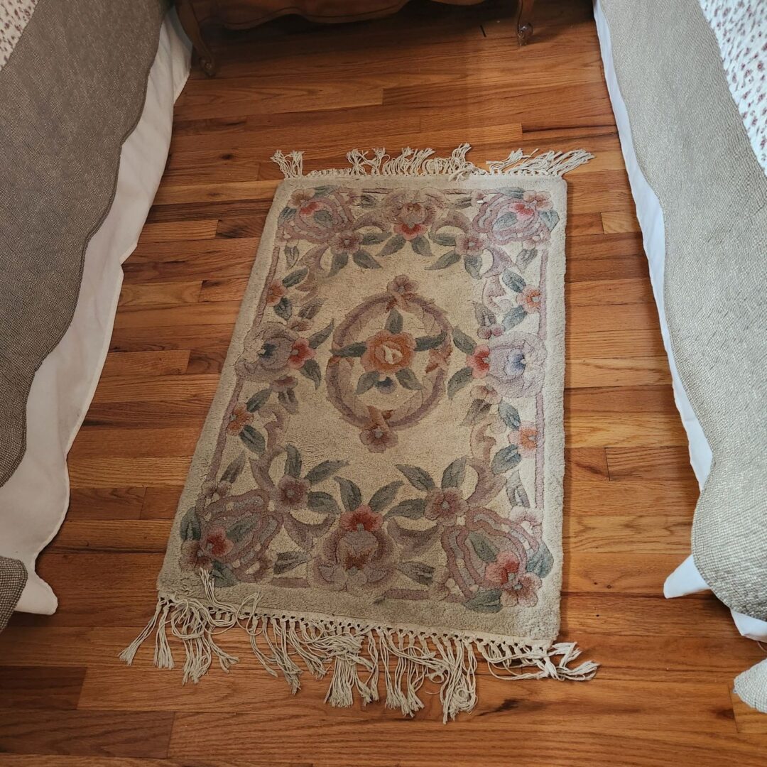 A rug on the floor next to two beds