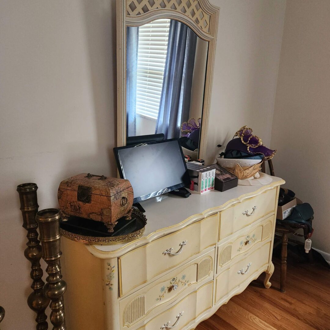 A yellow dresser with a mirror in a room