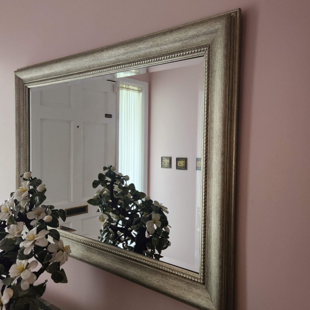 A Mirror With a Golden Frame With Vases